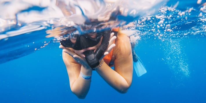 Happy woman snorkeling along a whale shark